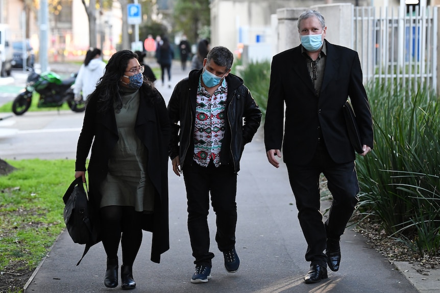 Mark James (right), son of Maria James departs from the Coroners Court of Victoria in Melbourne, wearing a mask.