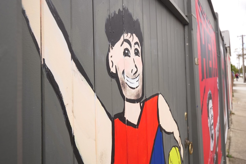 A player in a Demon's jumper is painted onto a wall.