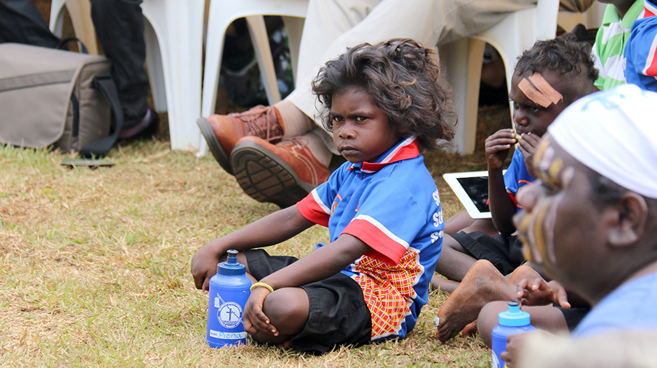 A child sits at the unveiling of the statue of Matthias Ulungura