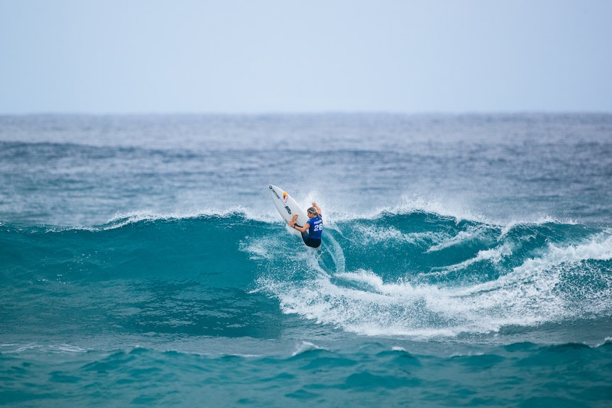 Molly Picklum surfs up a wave and cuts to her left 