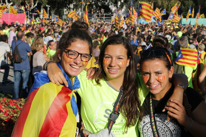 three young girls pose at a protest