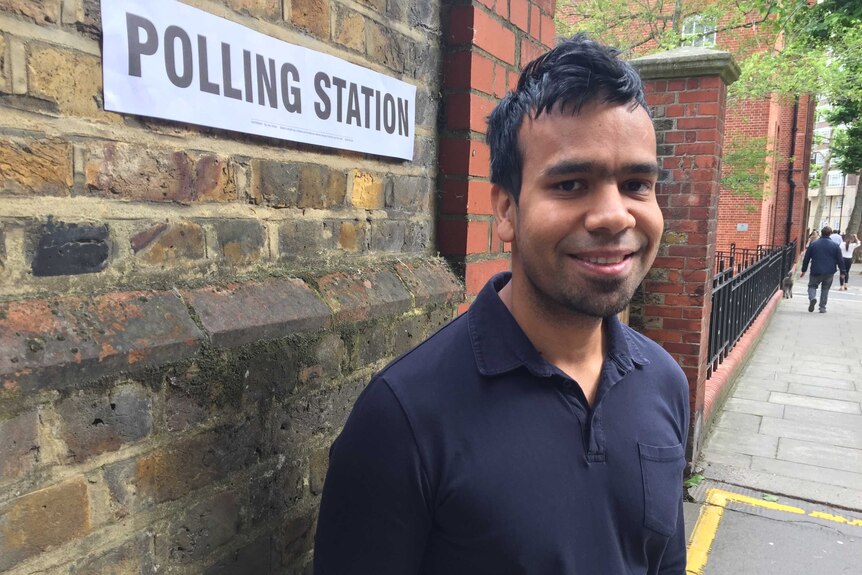 Voter Abul Monsor stands on the street in front of a polling station.