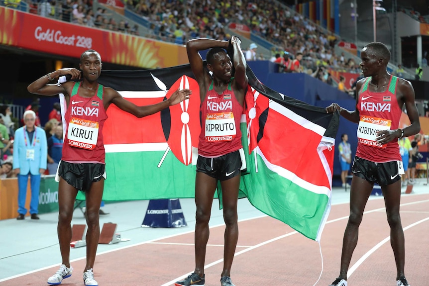 Kenya's Conseslus Kipruto (C), Abraham Kibiwott and Amos Kirui celebrate after the men's 3,000m steeplechase.