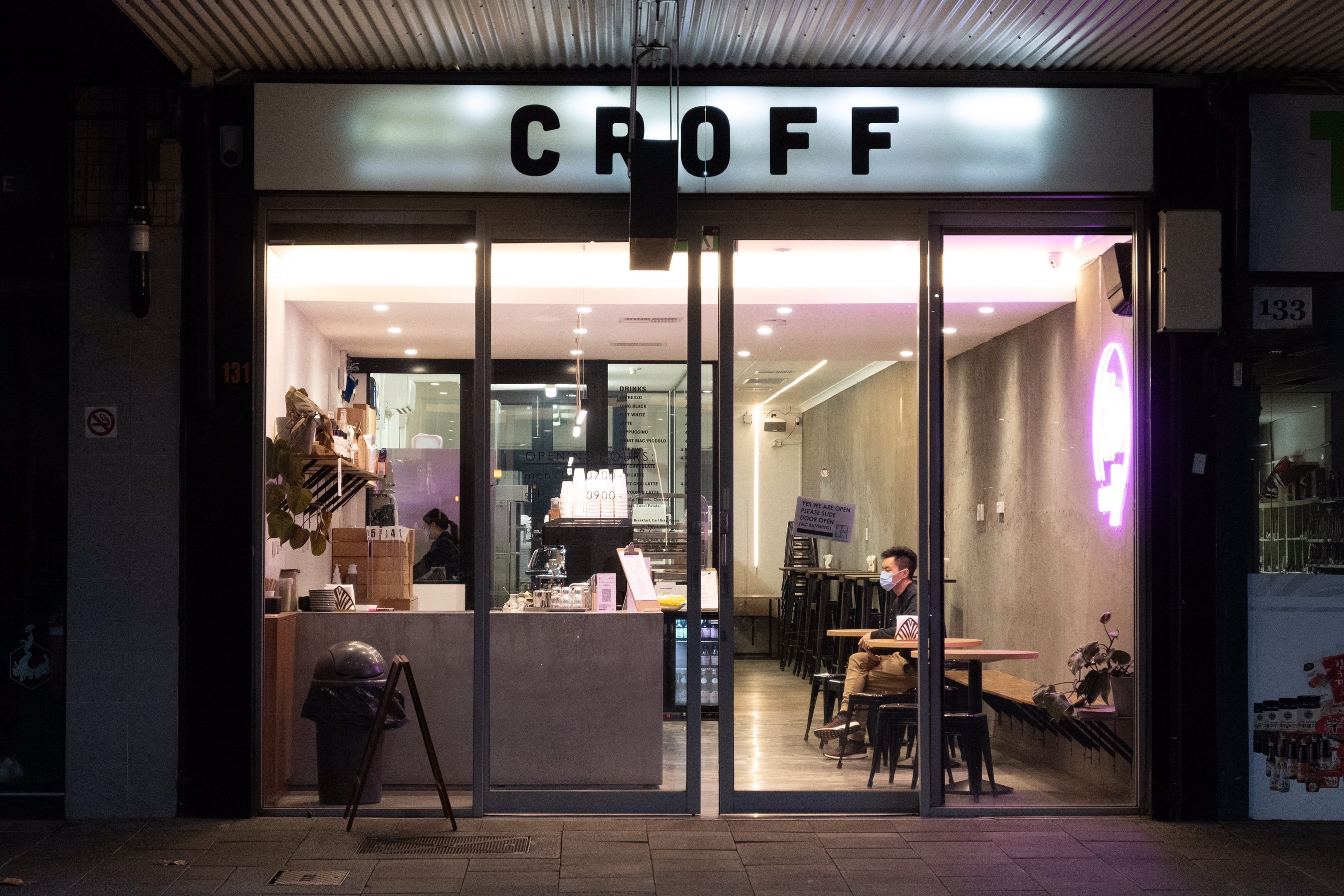 A man wearing a face mask sits in Croff Cafe on Barrack Street in Perth.