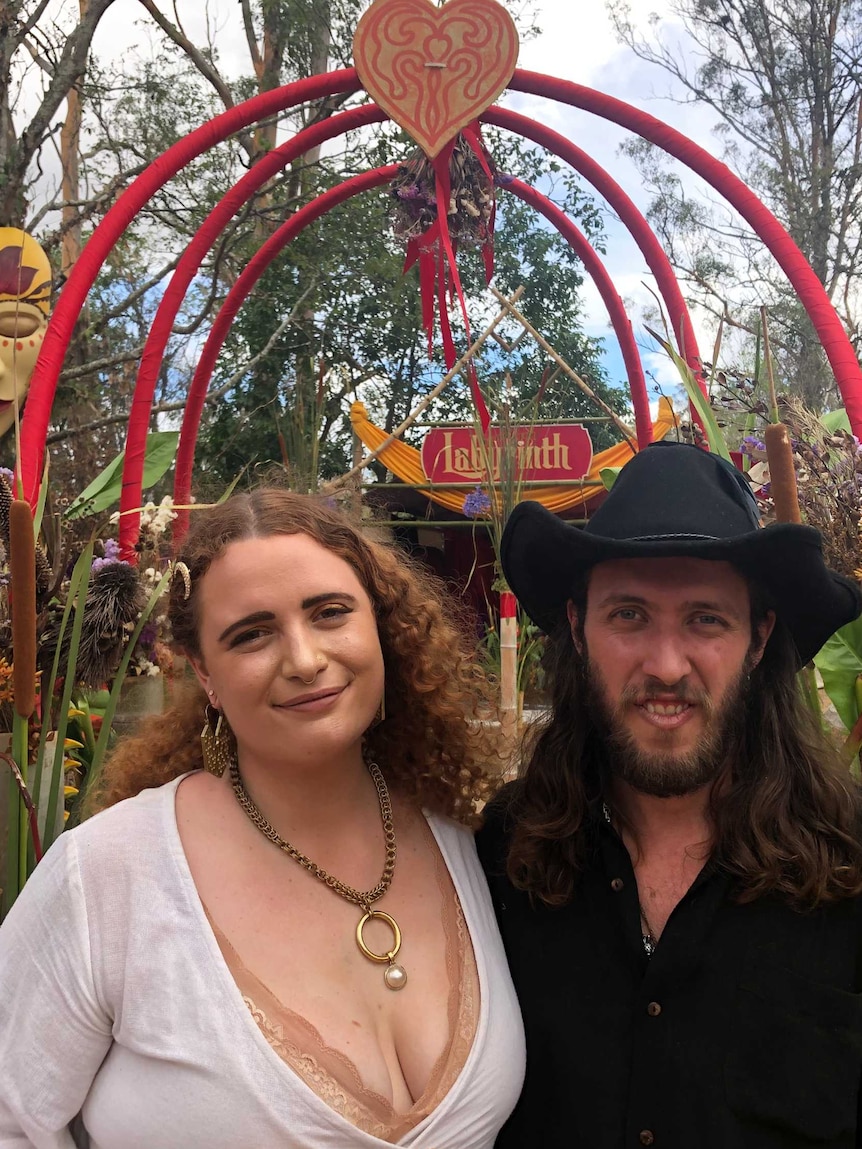 A woman and a man standing beneath a red archway.