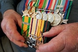 Harry Lock holds his war medals from WW2.