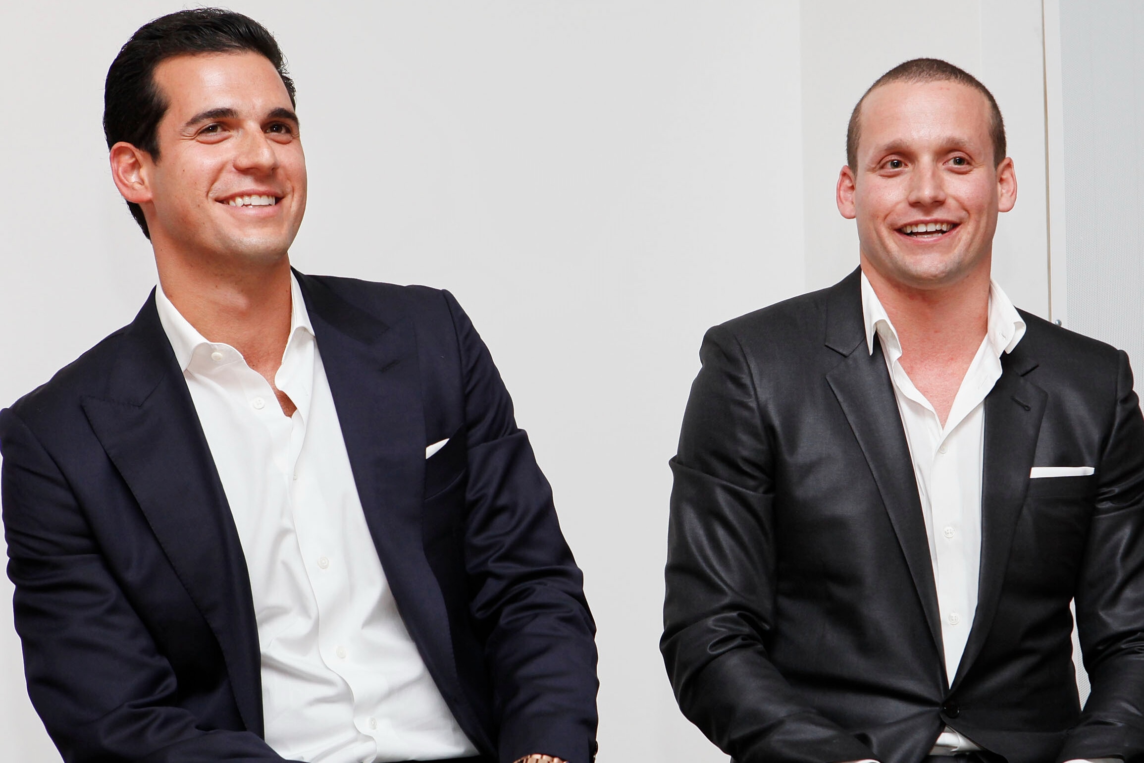 Oren and Tal Alexander pose for a picture wearing matching suits.