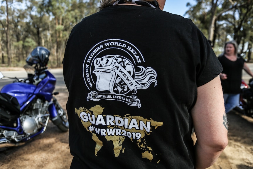 The back of a woman's t-shirt with Women World Riders Relay logo printed on it.
