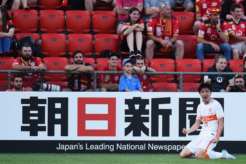 Shandong Luneng's Yang Xu celebrates opening the scoring in front of Adelaide United fans