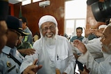 Indonesian radical Muslim cleric Abu Bakar Bashir greets supporters
