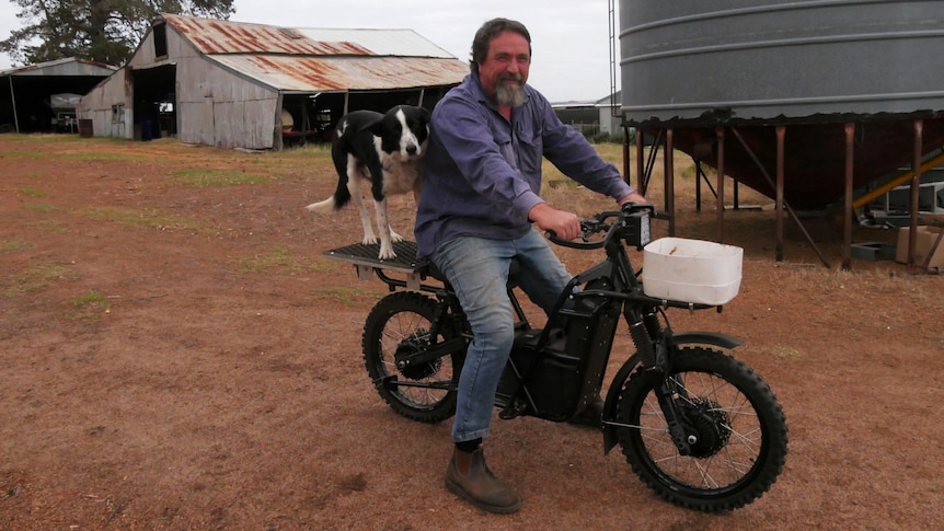 a man and his dog sit on an UBCO electric motorcycle