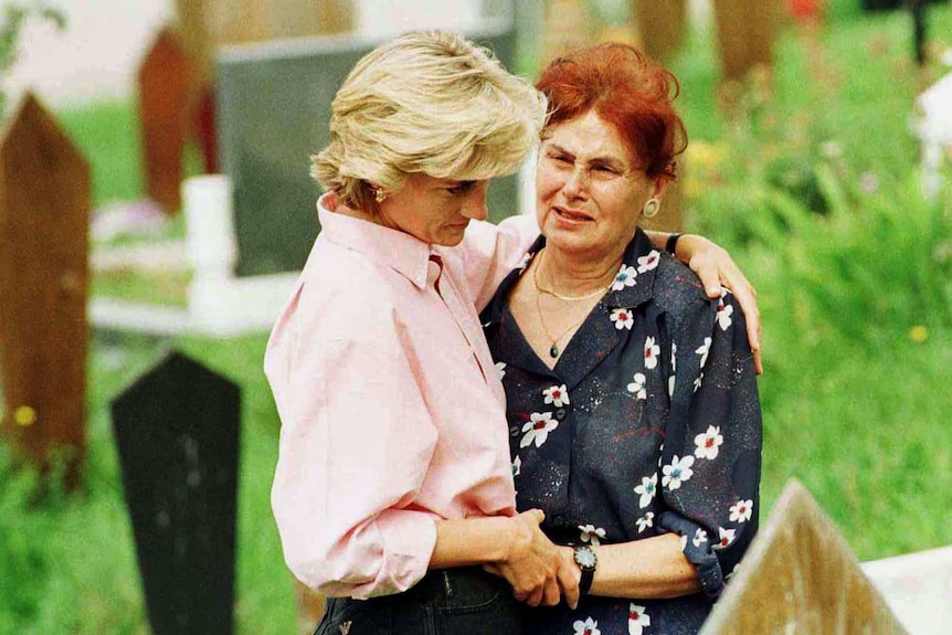 Diana, Princess of Wales, comforts an elderly woman during an early morning visit to Sarajevo's Lion cemetery August 10 1997.