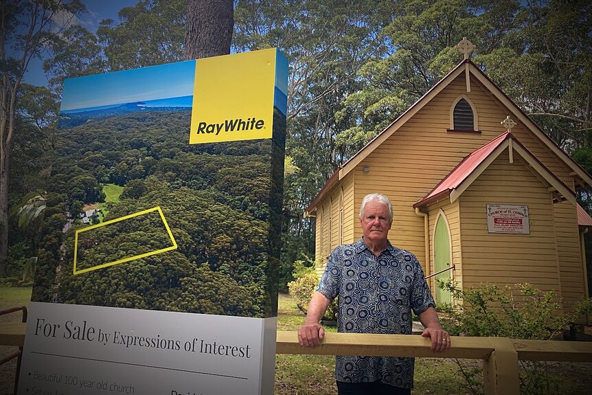 man standing near for sale real estate sign outside church