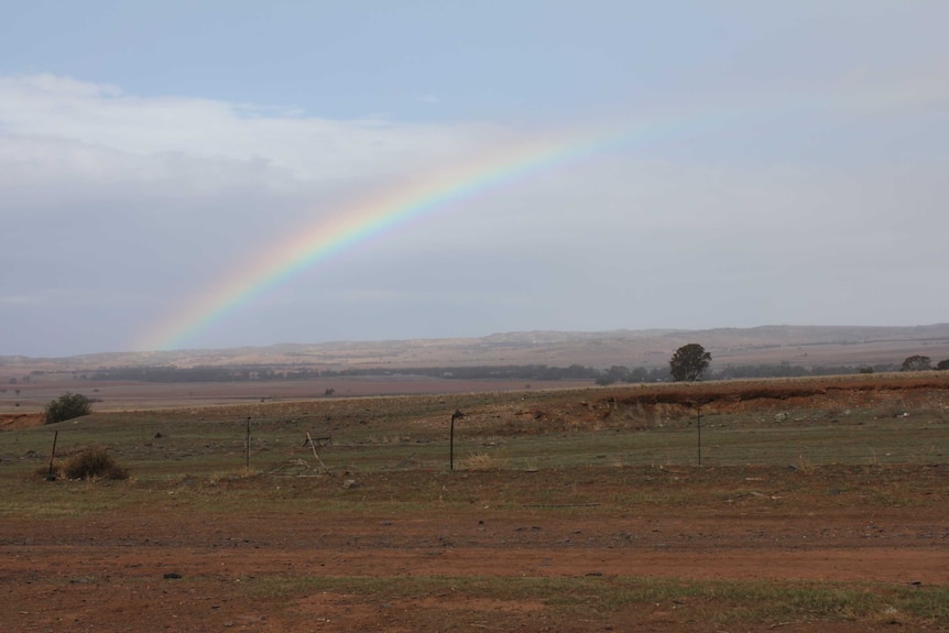 A rainbow over a mostly brown landscape.