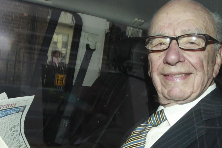 Rupert Murdoch reads The Sun on his way to office