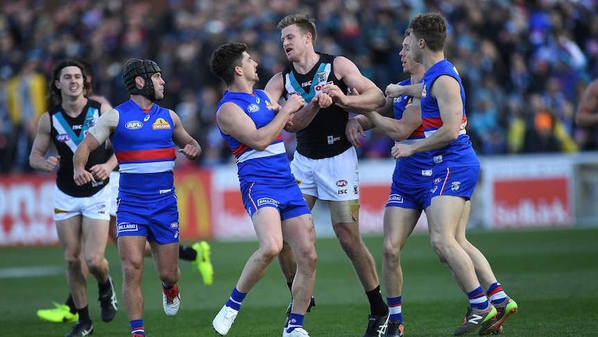 Port Adelaide's Tom Jonas (4th L) wrestles with Western Bulldogs players in Ballarat.