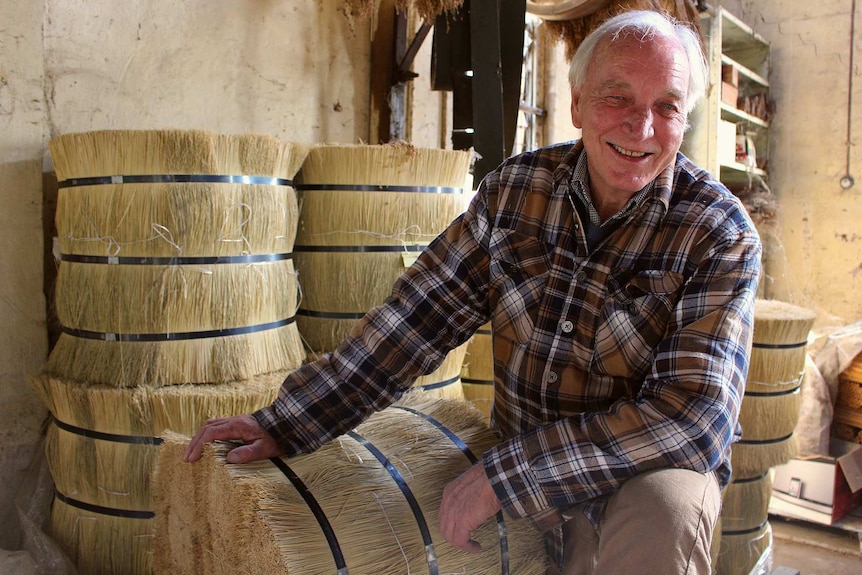 Factory owner Geoff Wortes sits on bales of millet.