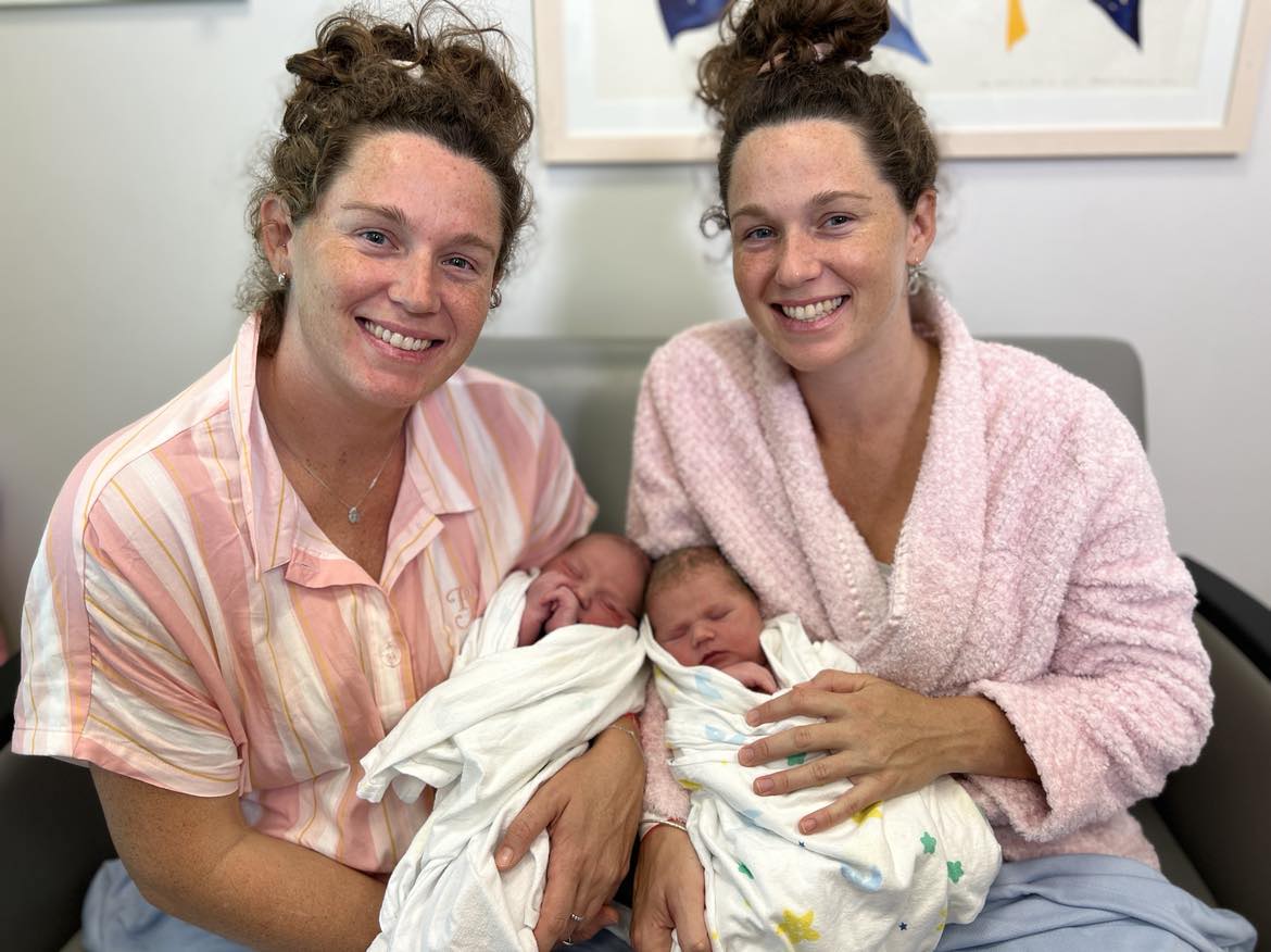 Twin sisters holding babies