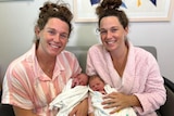 Twin sisters holding babies