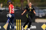 A smiling female fast bowler celebrates a clean-bowled ODI wicket as the batter walks off.