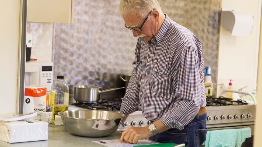 72-year-old John Shapely looks at cooking instructions.