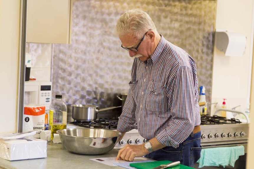 72-year-old John Shapely looks at cooking instructions.