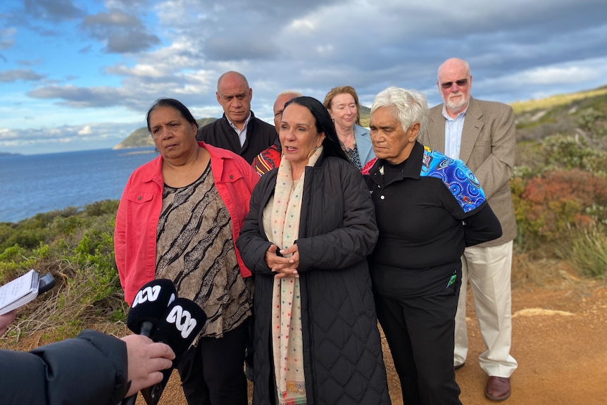 A crowd of people responding to questions at a press conference.