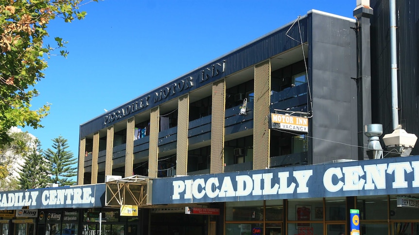 A low high-rise building that says "Piccadilly Centre", with a smaller sign saying "Motor Inn".