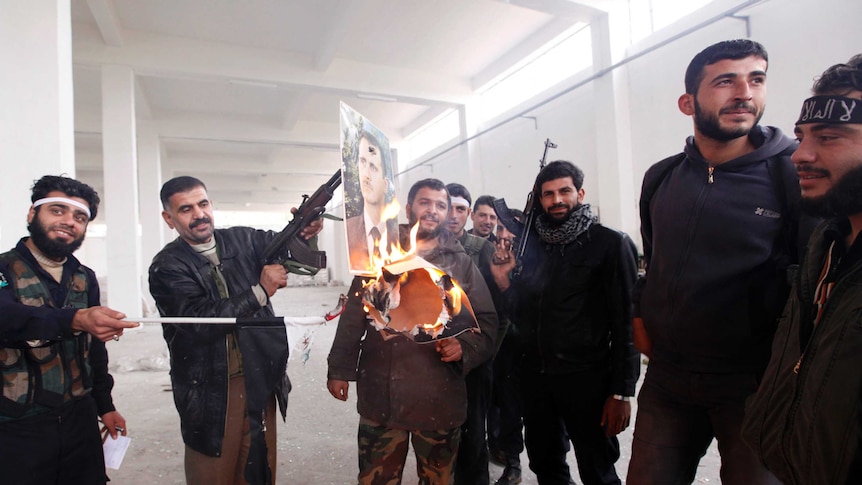 Free Syrian Army fighters burn a portrait of Bashar al-Assad in Aleppo.