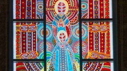 A brightly-coloured stained glass windows with Aboriginal designs.