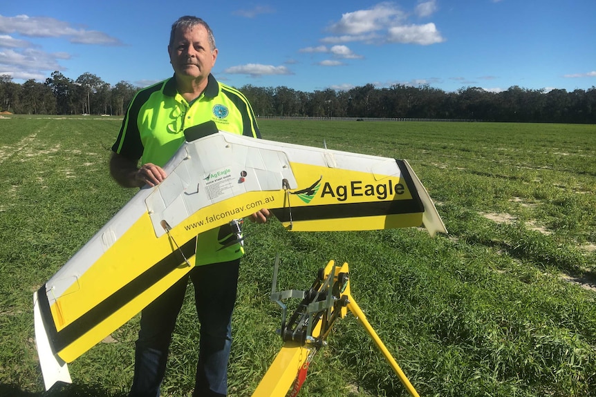 Tony Gilbert holding a fixed wing drone.