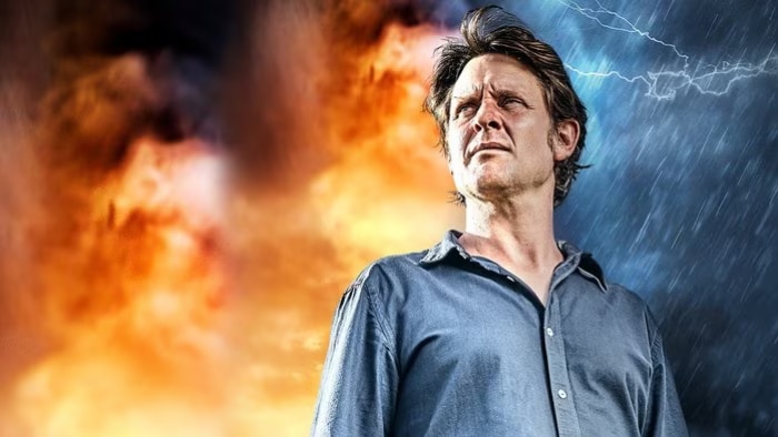 Craig Reucassel stands in front of a digital graphic of thunderstorms and fire.