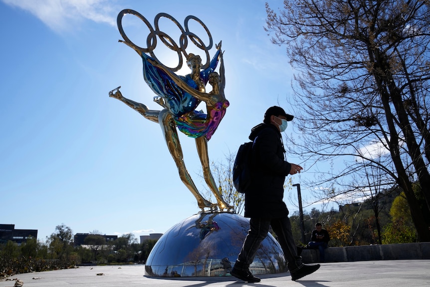 Un visitatore passa davanti a una statua delle Olimpiadi invernali di Pechino