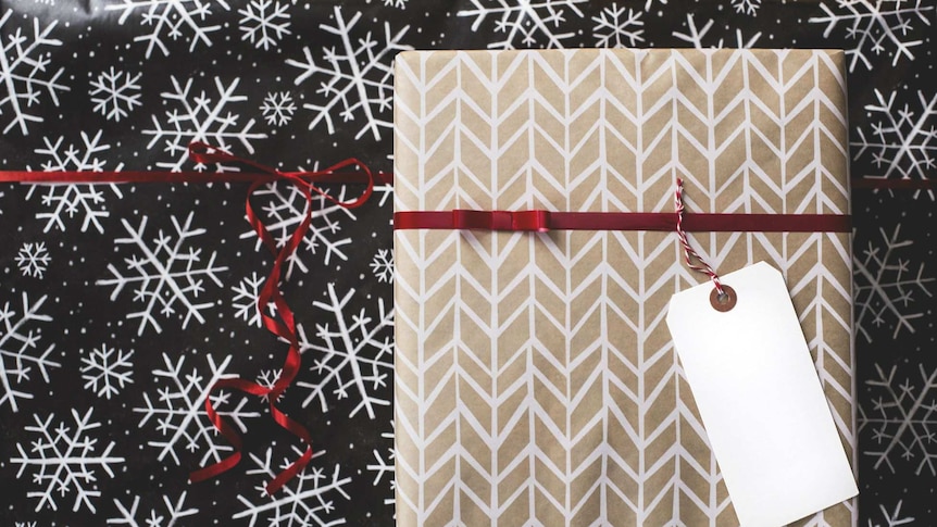 A Christmas present sits on top of wrapping paper.