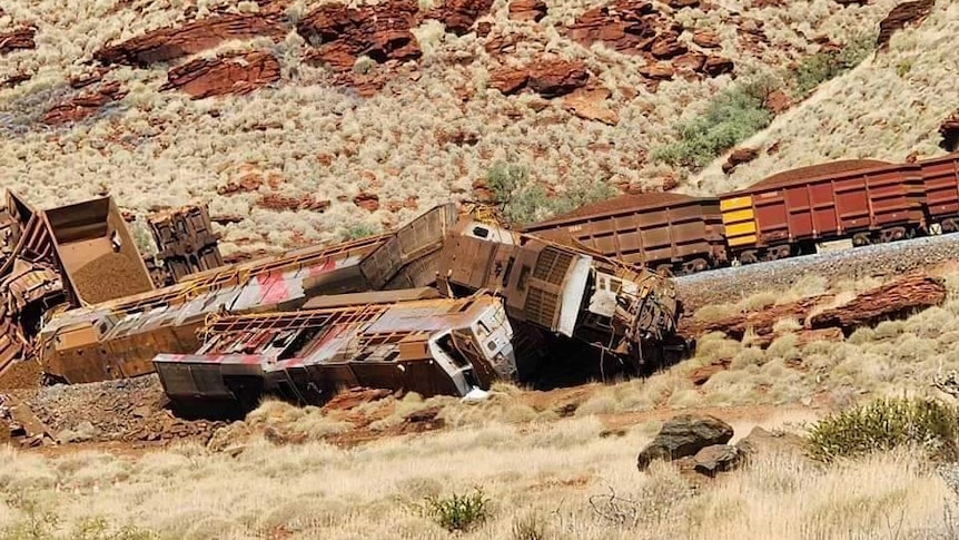 Overturned rail cars with iron ore in them. 