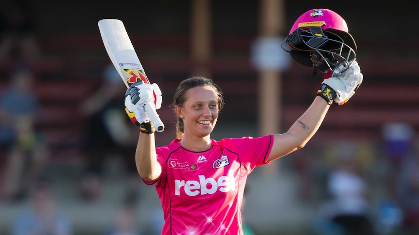Ashleigh Gardner raises her bat to acknowledge the crowd after reaching her half-century in the WBBL.