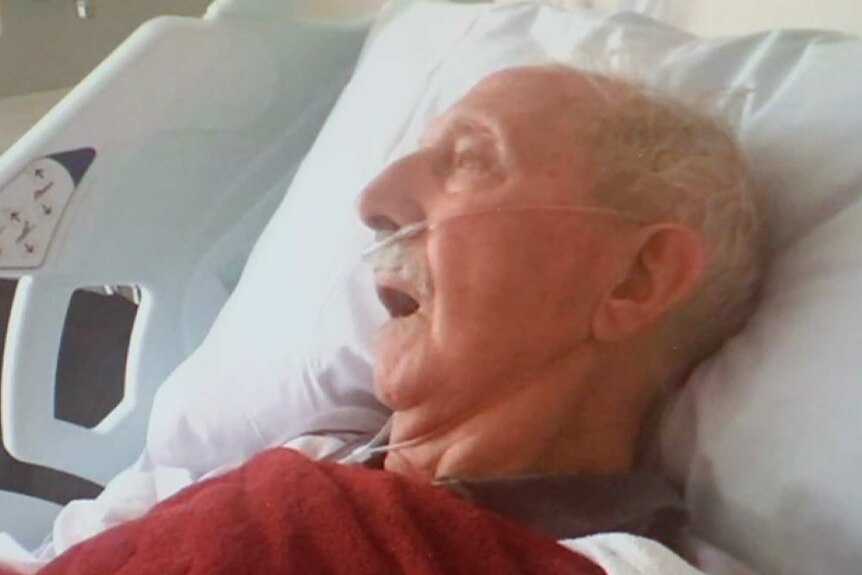 John Talifera in a hospital bed with tubes attached to his nose