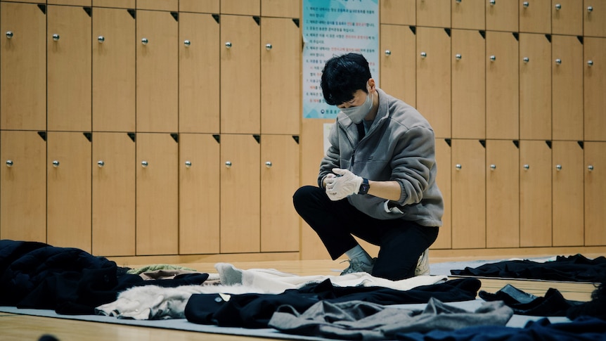 A man studies objects at a lost-and-found center where the belongings left during Seoul's Halloween crush are displayed. 