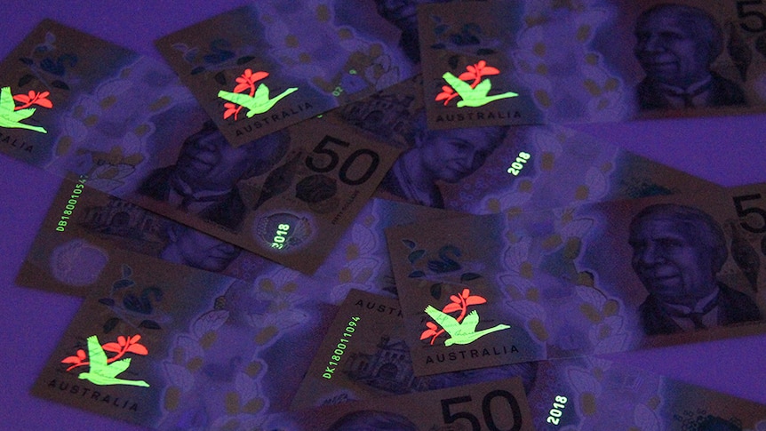 An image of a bird on the new $50 note illuminates under a UV light.