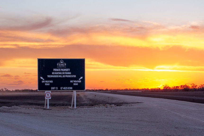 A large sign at Cubbie Station backlit by the setting sun in October, 2019.