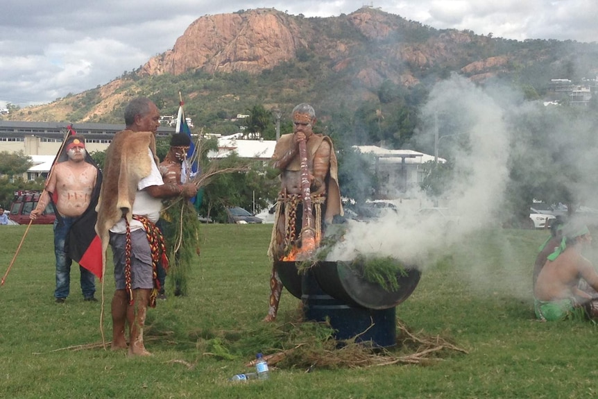 Indigenous men perform a smoking ceremony in Townsville