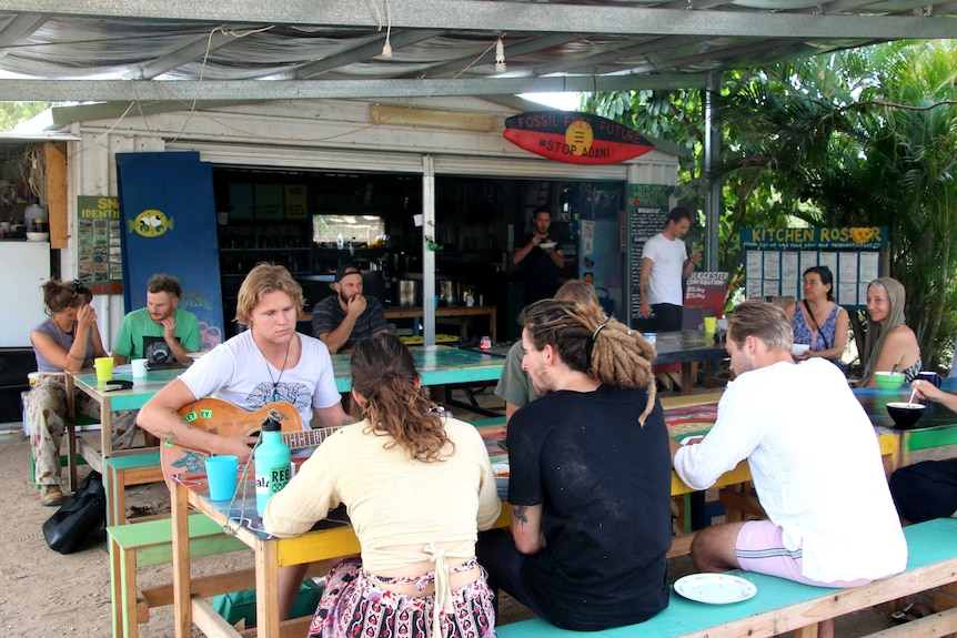 A group of people sitting at tables at a protest camp