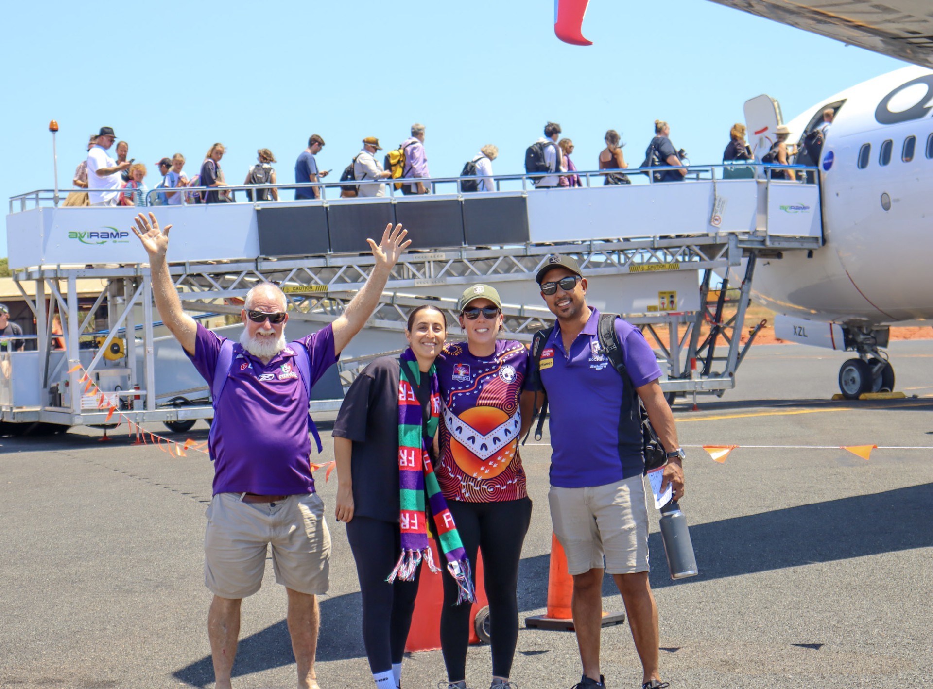 Dockers fans pose on the tarmac of Broome airport