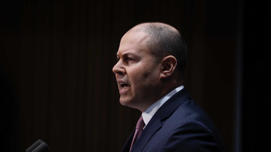 Josh Frydenberg speaks against a black background.