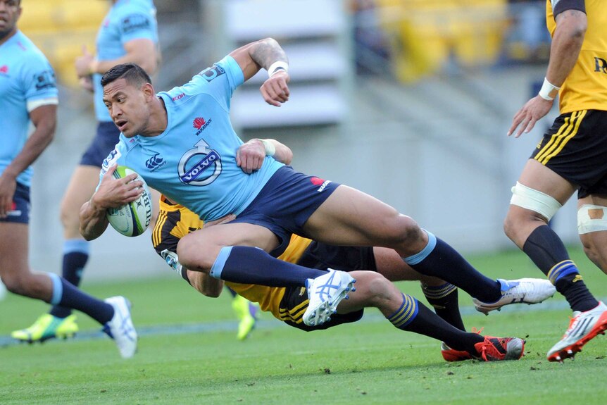 Israel Folau is brought down by the Hurricanes defence