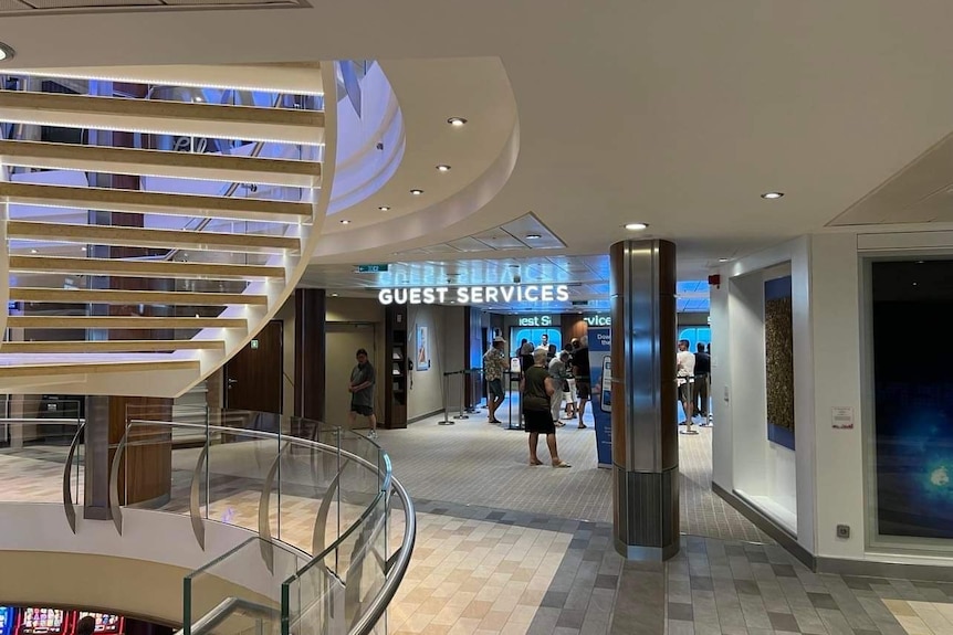 an office inside a cruise ship with the words 'guest services' above the door in lights