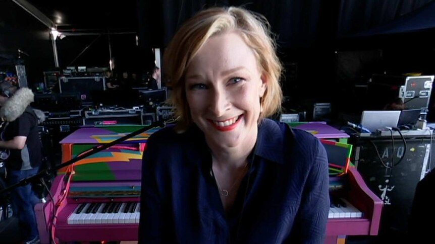 A smiling Leigh Sales sits at Paul McCartney's Magic piano