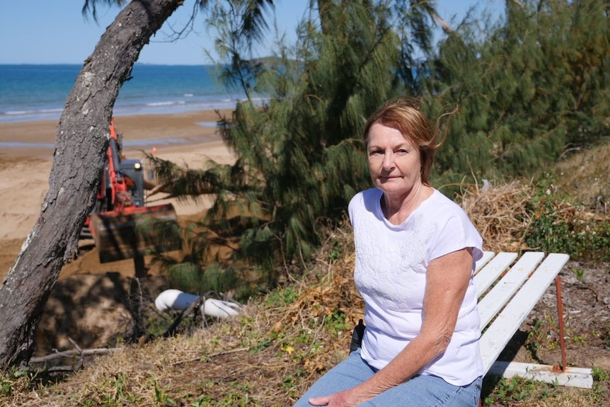 Resident Merle Lovett sits on a dune near where a whale carcass was found on Sarina Beach.