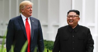 Donald Trump and Kim Jong-un walk together.