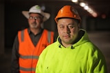 Two men on a construction site wearing high-vis